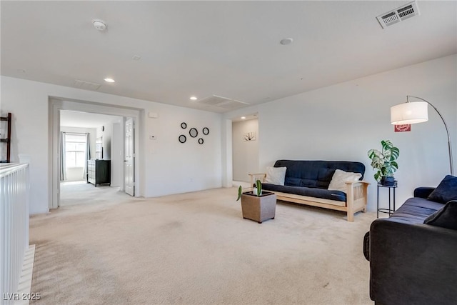 living room with recessed lighting, visible vents, and light carpet