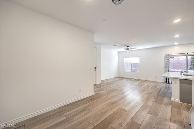 unfurnished living room featuring light hardwood / wood-style flooring and ceiling fan