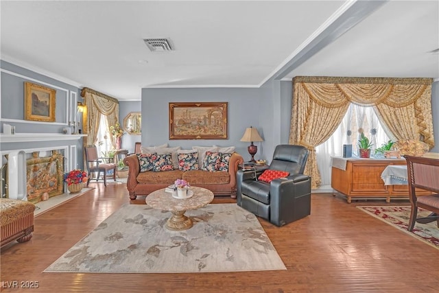 living area featuring hardwood / wood-style floors, a wealth of natural light, and crown molding