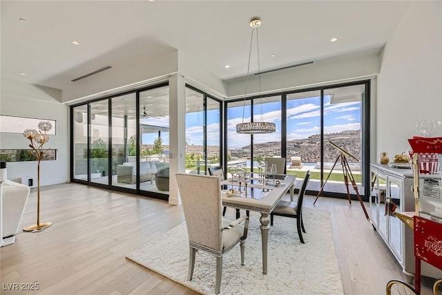 dining space featuring plenty of natural light, recessed lighting, visible vents, and wood finished floors