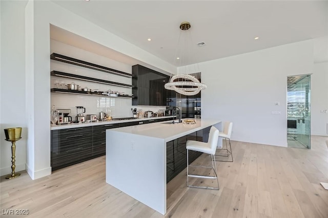 bar with stainless steel built in refrigerator, recessed lighting, pendant lighting, and light wood-style floors