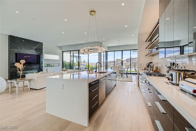 kitchen with a large island, light wood-style flooring, modern cabinets, and a sink