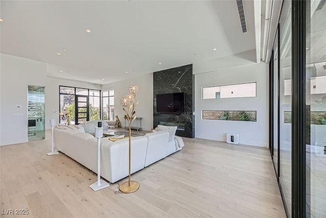 unfurnished living room featuring visible vents, recessed lighting, and light wood-type flooring