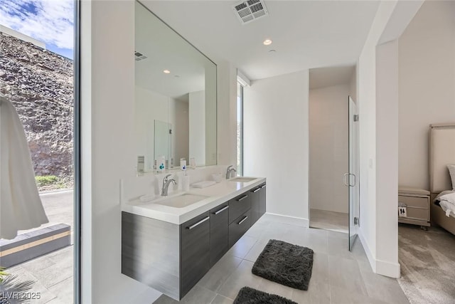 ensuite bathroom featuring double vanity, visible vents, ensuite bath, and a sink