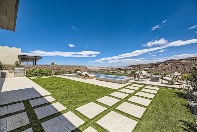 view of yard featuring an outdoor fire pit, an in ground hot tub, and a patio area