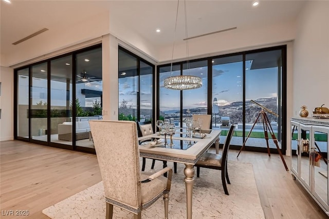 sunroom with plenty of natural light and ceiling fan with notable chandelier