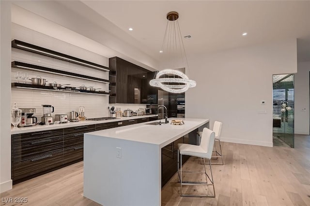 kitchen with open shelves, modern cabinets, a sink, and light countertops