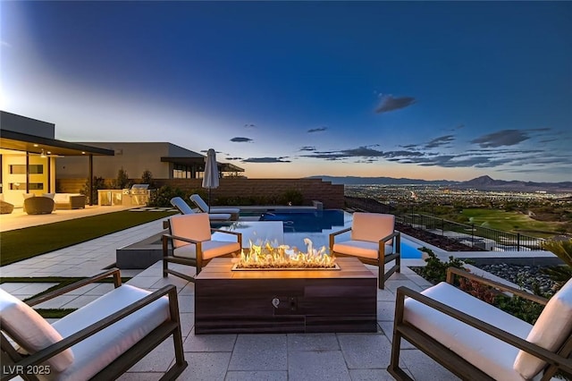 exterior space with a patio area, an outdoor living space with a fire pit, and a mountain view