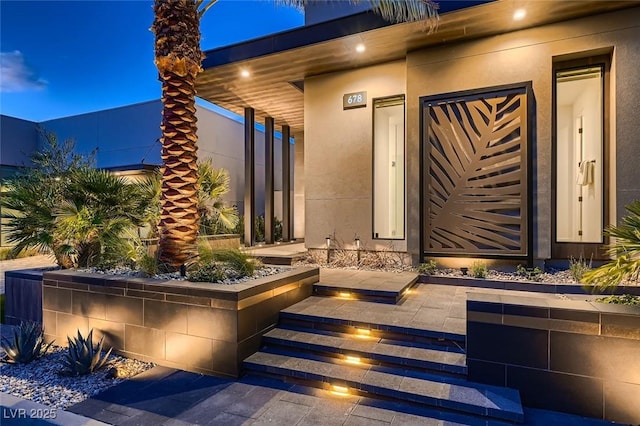 view of exterior entry featuring stucco siding