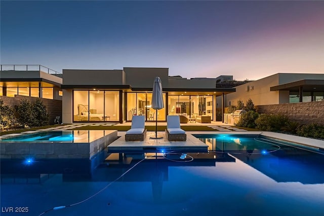 pool at dusk featuring an in ground hot tub, fence, an outdoor pool, and a patio