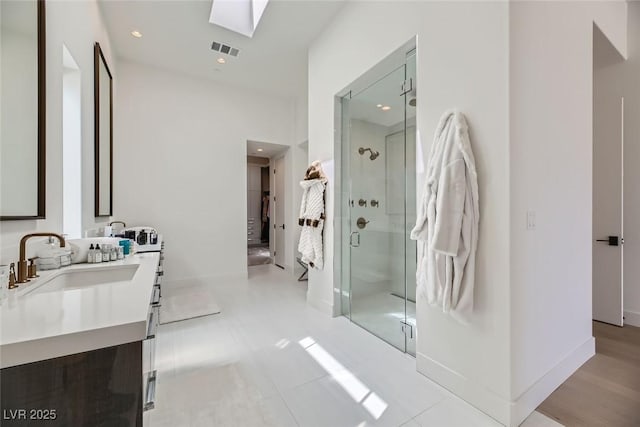 ensuite bathroom featuring visible vents, a stall shower, a sink, ensuite bath, and a skylight