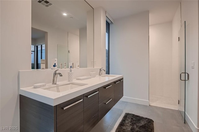 bathroom with double vanity, visible vents, a stall shower, and a sink