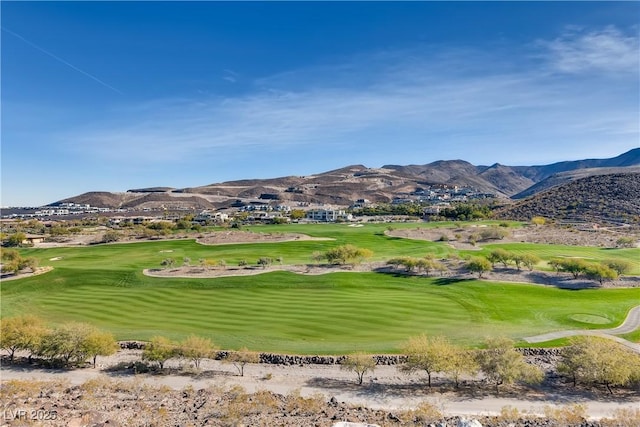 view of community featuring a mountain view, a yard, and view of golf course