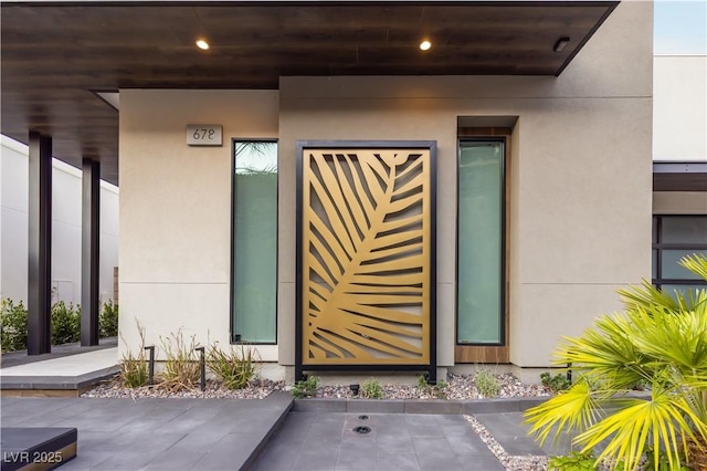 doorway to property featuring stucco siding