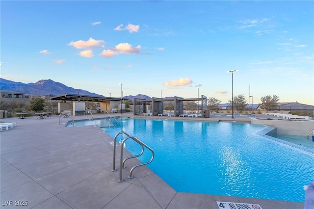 view of swimming pool with a patio area and a mountain view