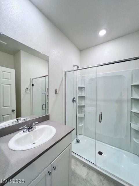 bathroom featuring an enclosed shower and vanity