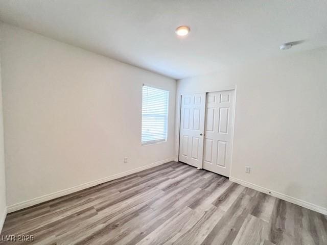 unfurnished bedroom featuring a closet and light hardwood / wood-style flooring