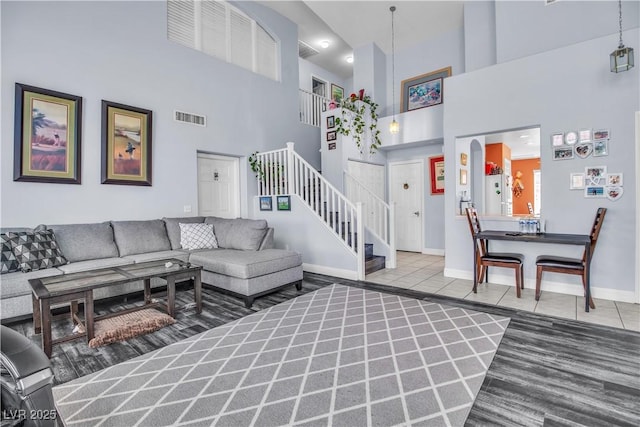 living room with tile patterned flooring and a towering ceiling