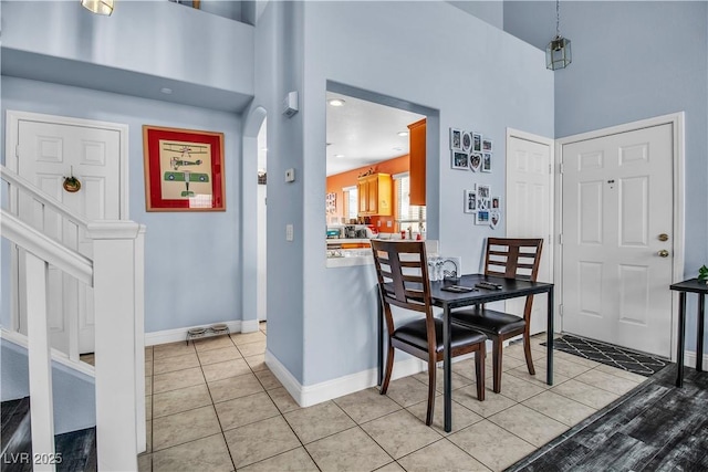 dining room featuring a high ceiling and light tile patterned flooring