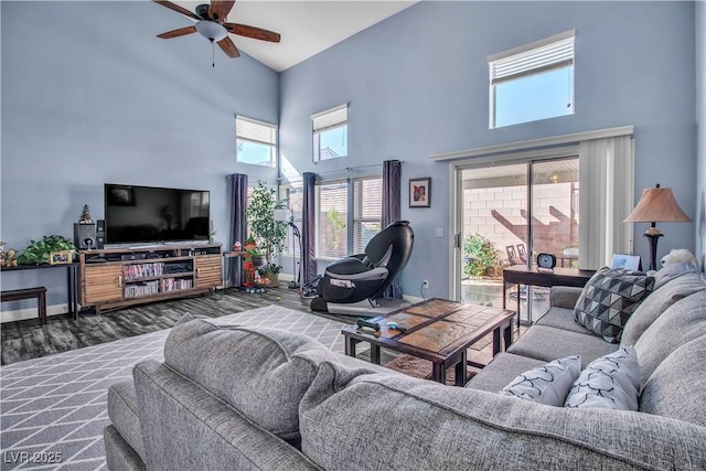 living room featuring ceiling fan, dark wood-type flooring, and a towering ceiling