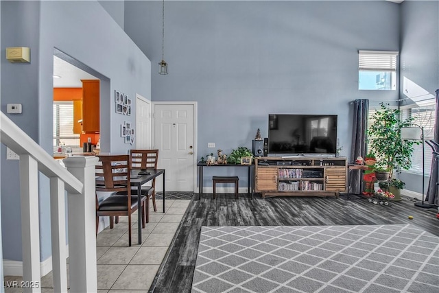 tiled living room featuring a high ceiling and a healthy amount of sunlight