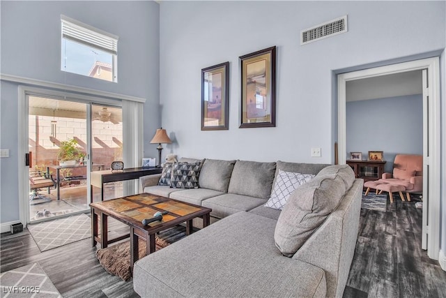 living room featuring dark hardwood / wood-style flooring and a towering ceiling