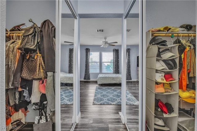 walk in closet featuring dark hardwood / wood-style flooring and ceiling fan