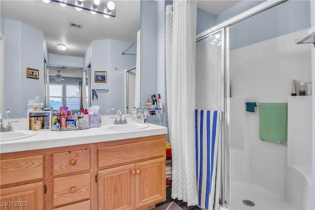 bathroom with vanity, an enclosed shower, and ceiling fan