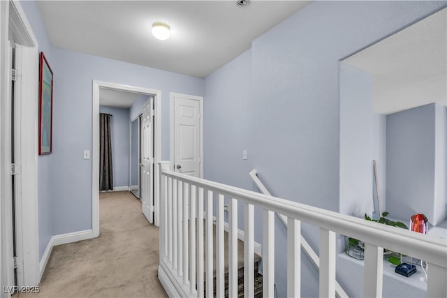 hallway featuring light colored carpet