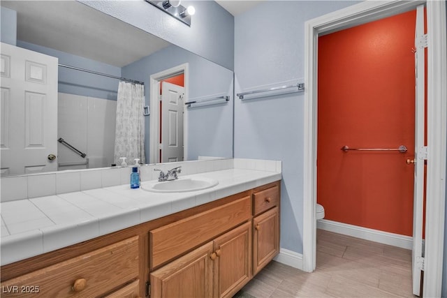 bathroom featuring toilet, vanity, and curtained shower