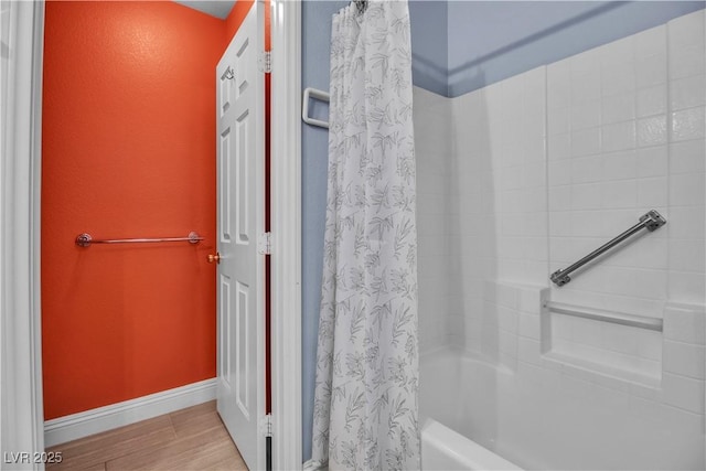 bathroom with shower / bath combination with curtain and wood-type flooring