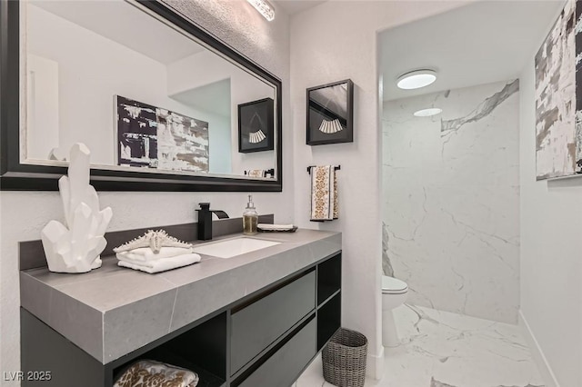 bathroom featuring marble finish floor, baseboards, vanity, and toilet