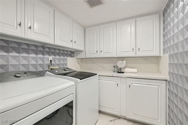 laundry area with cabinet space, visible vents, and washer and clothes dryer