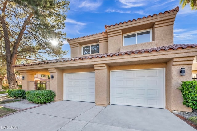 mediterranean / spanish-style house with a garage, concrete driveway, fence, and stucco siding