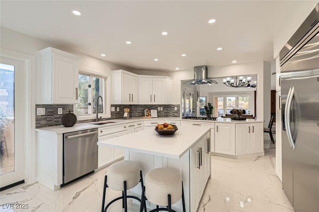 4961 Tierra Del Sol Dr, Las Vegas, NV 89113 - kitchen featuring stainless steel appliances, a kitchen island, light marble finish floors, decorative backsplash, and recessed lighting