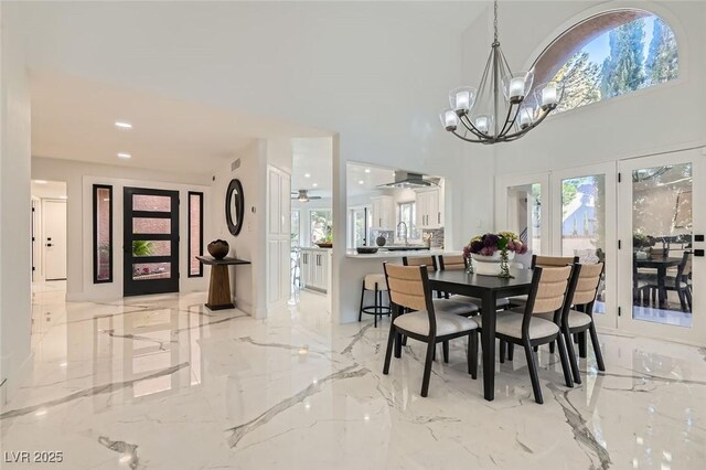 4961 Tierra Del Sol Dr, Las Vegas, NV 89113 - dining space with light marble finish flooring, a chandelier, and plenty of natural light