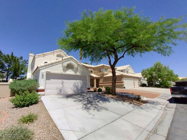 view of front of property featuring a garage, driveway, and a tiled roof