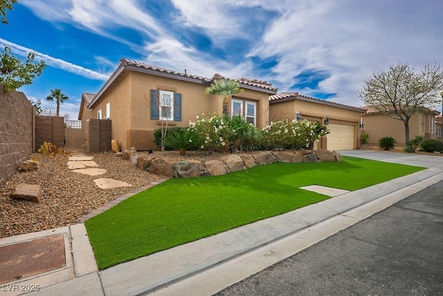 mediterranean / spanish-style home with a garage, fence, driveway, stucco siding, and a front yard