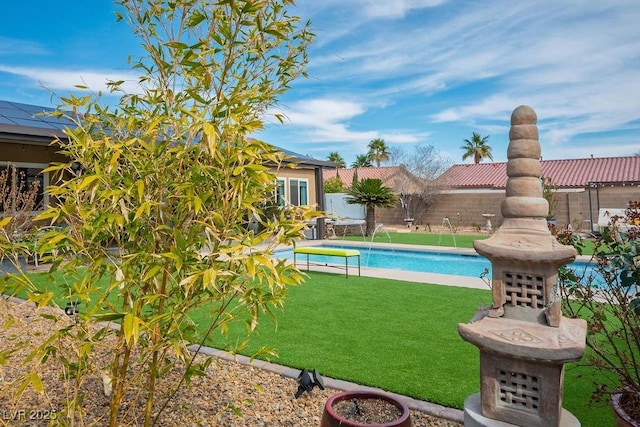 pool with a fenced backyard and a yard