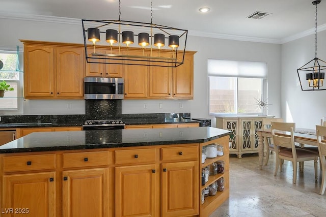 kitchen with visible vents, range, a center island, stainless steel microwave, and pendant lighting