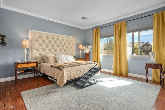 bedroom with dark wood-style floors, visible vents, ornamental molding, and baseboards