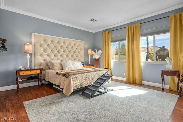 bedroom featuring dark wood-style floors, baseboards, visible vents, and crown molding