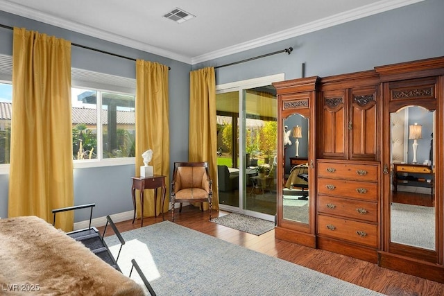 living area featuring baseboards, visible vents, crown molding, and wood finished floors