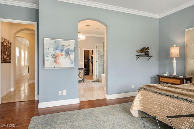 bedroom featuring arched walkways, ornamental molding, dark wood finished floors, and baseboards