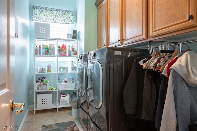 clothes washing area featuring cabinet space, baseboards, and washer and clothes dryer