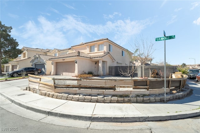 view of front of home with concrete driveway, a tile roof, an attached garage, fence, and stucco siding