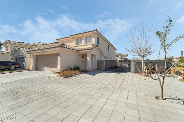 mediterranean / spanish-style house featuring an attached garage, fence, a tile roof, driveway, and stucco siding