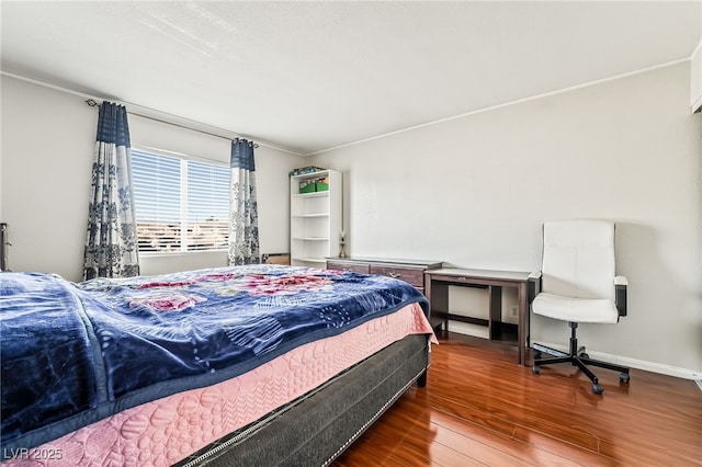 bedroom with baseboards and wood finished floors