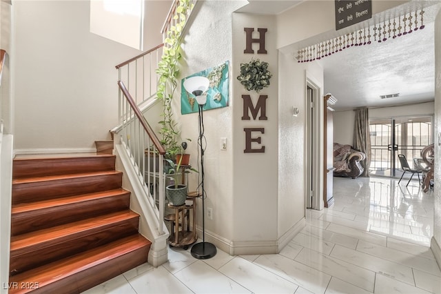 stairs featuring visible vents and baseboards