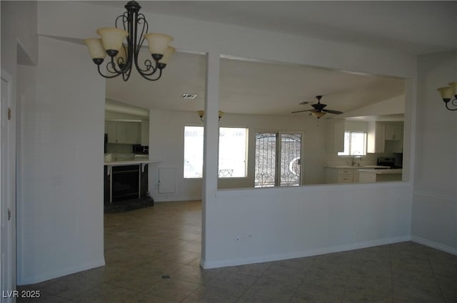 kitchen with dark tile patterned floors, wine cooler, and ceiling fan with notable chandelier